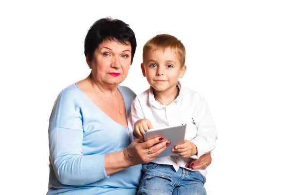 Abuela con su nieto utilizar una tableta sobre un fondo blanco — Foto de Stock