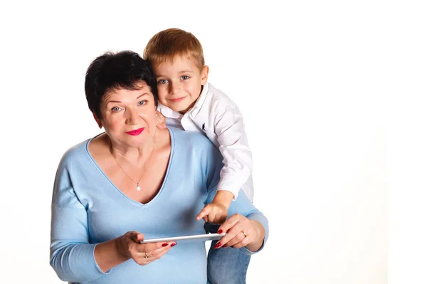 Abuela con su nieto utilizar una tableta sobre un fondo blanco — Foto de Stock