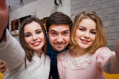 Neşeli genç arkadaşlar selfie bir kafede yapar