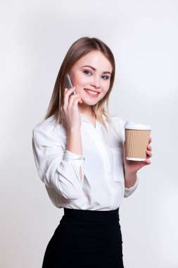Kahve ve telefon ile beyaz bir arka plan üzerinde genç çekici iş kız