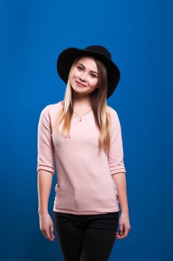 Mavi bir arka plan üzerinde şapkalı güzel genç kız