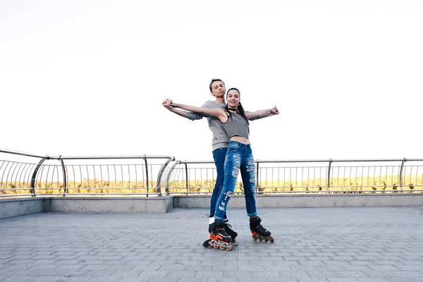 Schönes süßes Paar reitet auf Rollschuhen Händchen haltend — Stockfoto