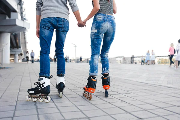 Ноги любящая пара в джинсах и роликовых коньках. Ездить на велосипеде — стоковое фото