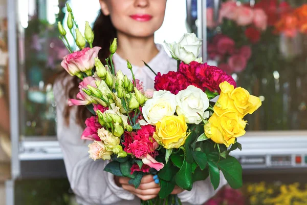 Симпатичная молодая флористка в очках работает в цветочном магазине — стоковое фото