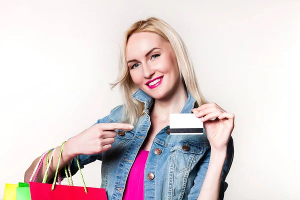Lachende meisje met boodschappentassen. creditcard in de handen — Stockfoto