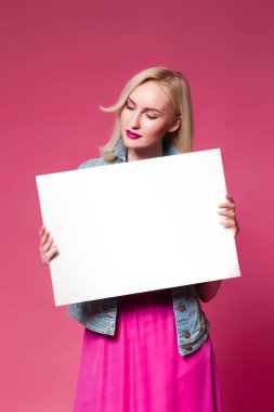 Alışveriş alışveriş torbaları, pembe arka plan tutan kadın. Metniniz için beyaz bir tabela tutar