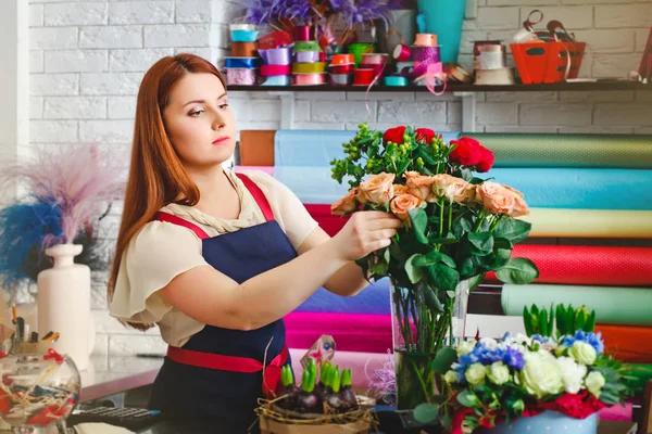 young girl working in a flower shop, Florist woman makes a bouquet