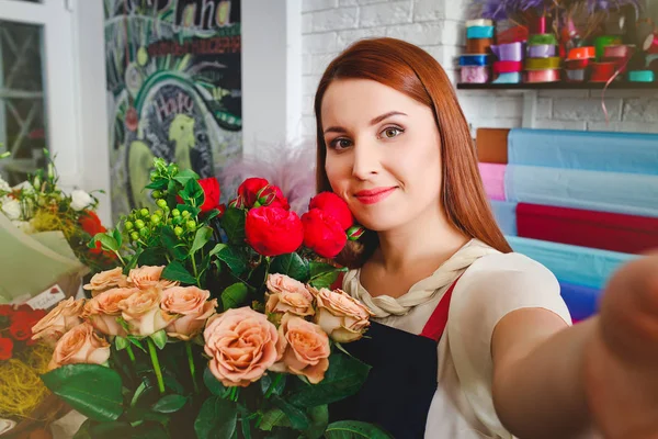 young girl working in a flower shop, Florist woman makes a bouquet