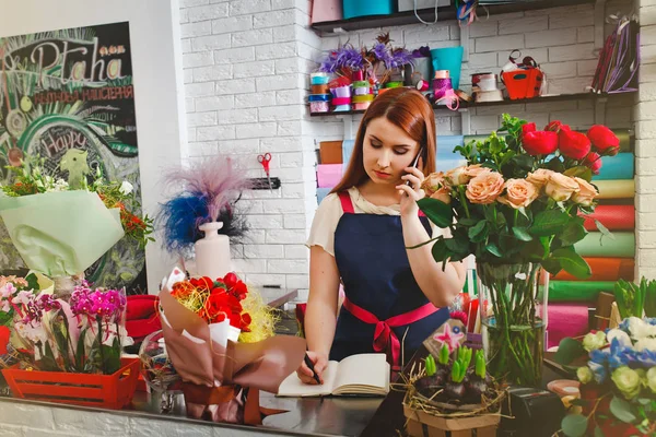 在一家花店工作的年轻女孩 — 图库照片