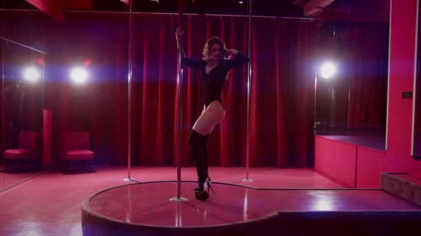 Vacker flicka dansar på en pylon på en rosa bakgrund — Stockvideo