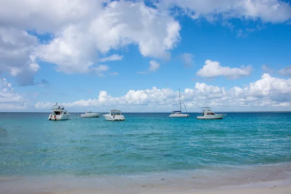 Weiße Hochgeschwindigkeitsboote stehen am Ufer des karibischen Meeres und blicken auf einen schönen Himmel mit weißen Wolken — Stockfoto