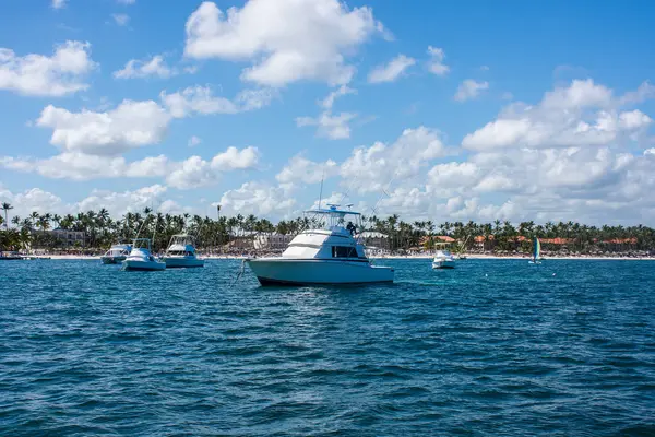 Fischerei in der Republik Dominica, ein weißes Fischerboot steht auf einem Steg in Küstennähe, vor dem Hintergrund von Palmen und einem blauen Himmel mit Wolken — Stockfoto