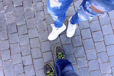 Bir adam ve bir kız spor ayakkabı içinde bacaklar bir blok taş üzerinde üstten görünüm durun