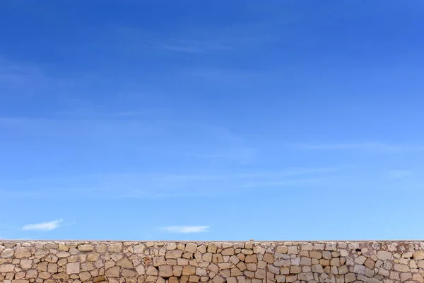 Taş duvar ve mavi gökyüzü bulutlu, metin için arka plan boş alan