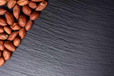 Kavrulmuş fıstık bir tahtada siyah taş, metin için yer soyulmuş