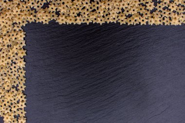 Makarna yıldız şeklinde bir taş yönetim kurulu, metin için yer siyah bir arka plan dayanmaktadır