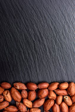 Kavrulmuş fıstık bir tahtada siyah taş, metin için yer soyulmuş