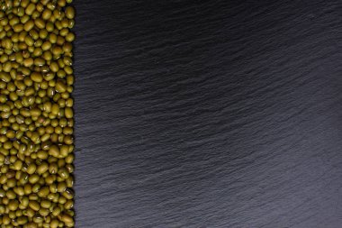 Mung fasulye yalanlar üzerine bir kara taş tahta arka plan, metin, fasulye için yer