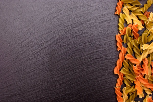 Renkli makarna yalan arduvaz arka plan, metin için yer siyah taş tahta üzerine