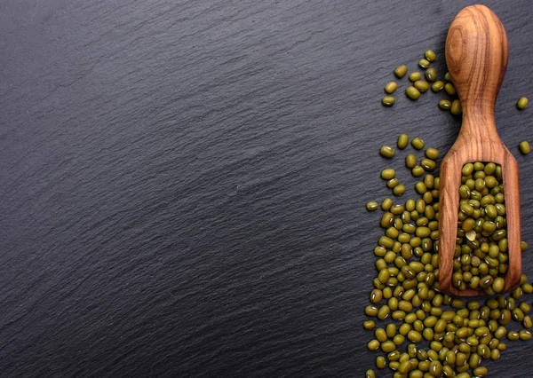 Arka plan siyah bir taş yönetim kurulu, metin, mung fasulye için yer üzerinde fasulye ahşap Kepçe