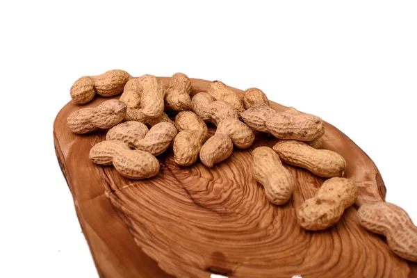 Jordnötter i en skal på en träskiva som isolerad på en vit bakgrund — Stockfoto