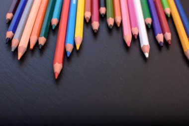 Siyah taş mazisi üzerinde birçok renkli kalemler yerleştirmek için metni