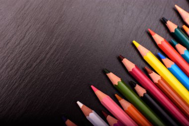 Siyah taş mazisi üzerinde birçok renkli kalemler yerleştirmek için metni