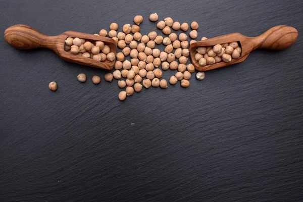 Siyah bir taş kurulu bir ahşap kepçeyle nohut, metin için yer yoktur