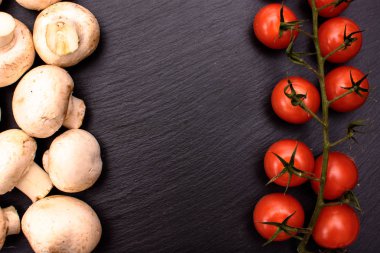 Kırmızı kiraz domates ve mantar mantar taş kara tahta üzerinde arka plan yalan