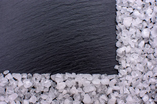 Tuz, sofra tuzu yalanlar üzerine siyah bir taş kara tahta çerçeveyi metin için yer şeklinde