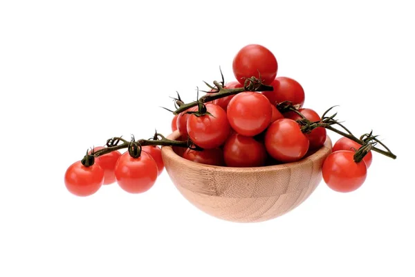 Tomates cereja vermelha encontram-se em uma xícara de madeira, isolado em um fundo branco — Fotografia de Stock