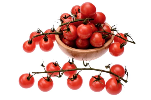 Red cherry tomatoes lie in a wooden cup, isolated on a white background — Stock Photo, Image