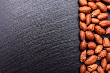 Kavrulmuş fıstık bir tahtada siyah taş, metin için yer soyulmuş