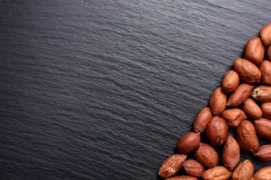 Kavrulmuş fıstık bir tahtada siyah taş, metin için yer soyulmuş