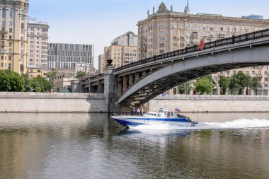 Şehrin bir setin evleriyle, nehrin metal bir köprü nehir boyunca bir tekne yelken