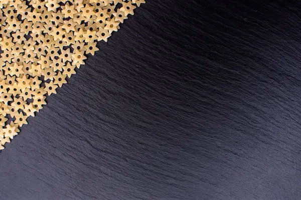 Makarna yıldız şeklinde bir taş yönetim kurulu, metin için yer siyah bir arka plan dayanmaktadır