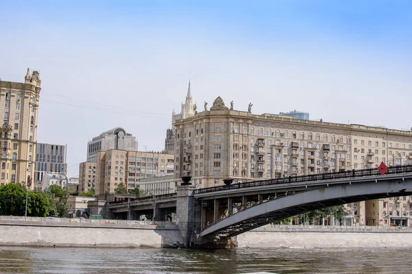 Pont métallique traversant la rivière jusqu'à la ville, remblai avec maisons — Photo