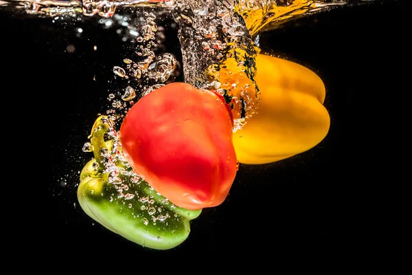 Salpicaduras de pimientos en el agua —  Fotos de Stock