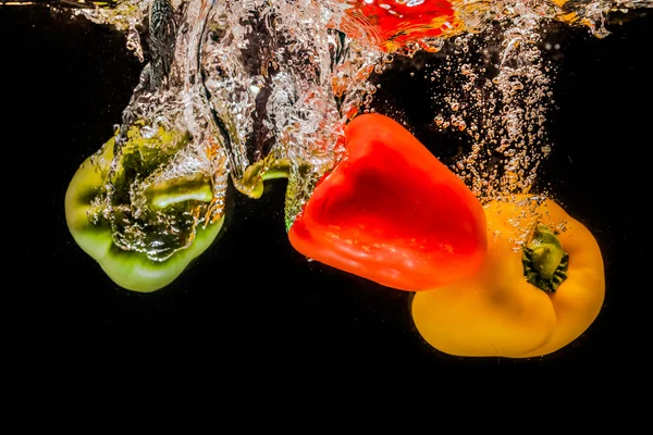 Salpicaduras de pimientos en el agua —  Fotos de Stock