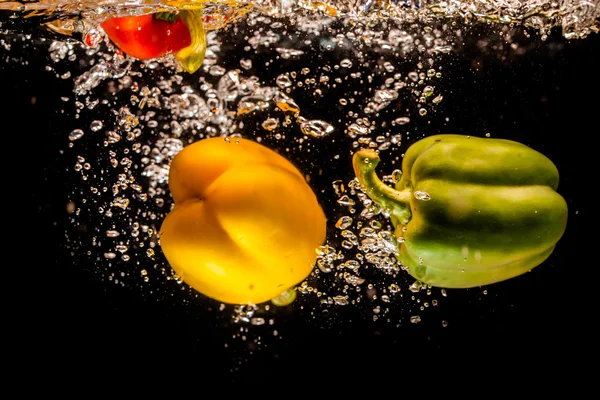 Salpicaduras de pimientos en el agua —  Fotos de Stock