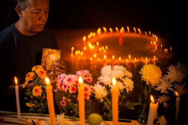 stock image fire on candles and a group of flowers to pray for the dead king