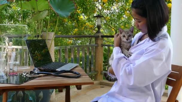 Eine Ärztin spielt mit ihrer Katze — Stockvideo