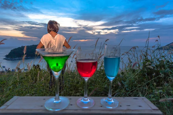 Eine Dame versammelt sich mit ein paar Getränken auf einem Hügel vor dem Aussichtspunkt der Windkraftanlage — Stockfoto