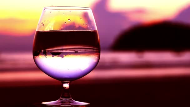 Un vaso de agua puesto en la playa — Vídeos de Stock