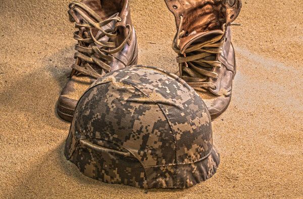soldier hat  boots and sand glass in the desert