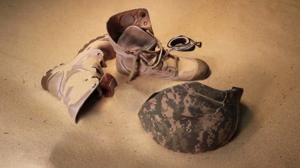 战士的帽子军靴和砂玻璃在沙漠中 — 图库视频影像