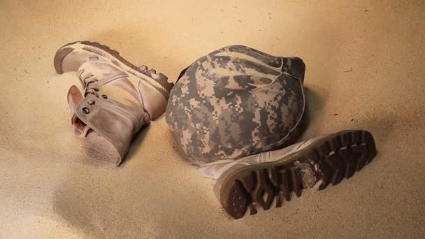 Soldaat hoed laarzen en zand glas in de woestijn — Stockvideo