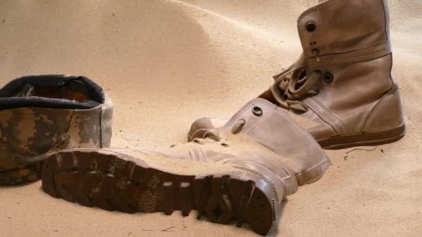战士的帽子军靴和砂玻璃在沙漠中 — 图库视频影像