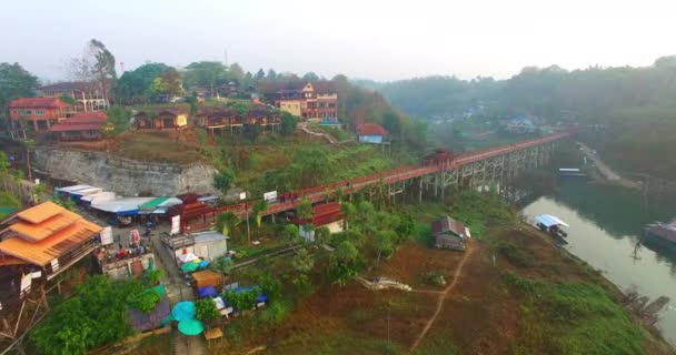 Luchtfoto vlotten en dorp rond de houten brug — Stockvideo
