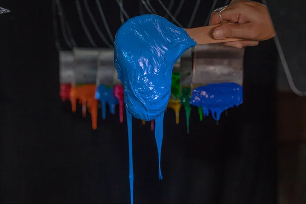 Kék plasztiszol tinta a fakanállal a gyári póló — Stock Fotó